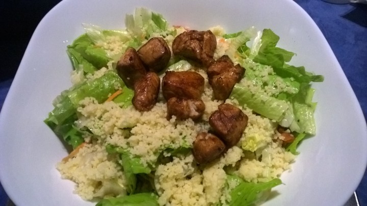 a salad with meat and rice in a white bowl