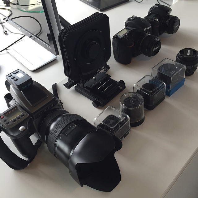 different sized cameras displayed on counter top in front of electronics
