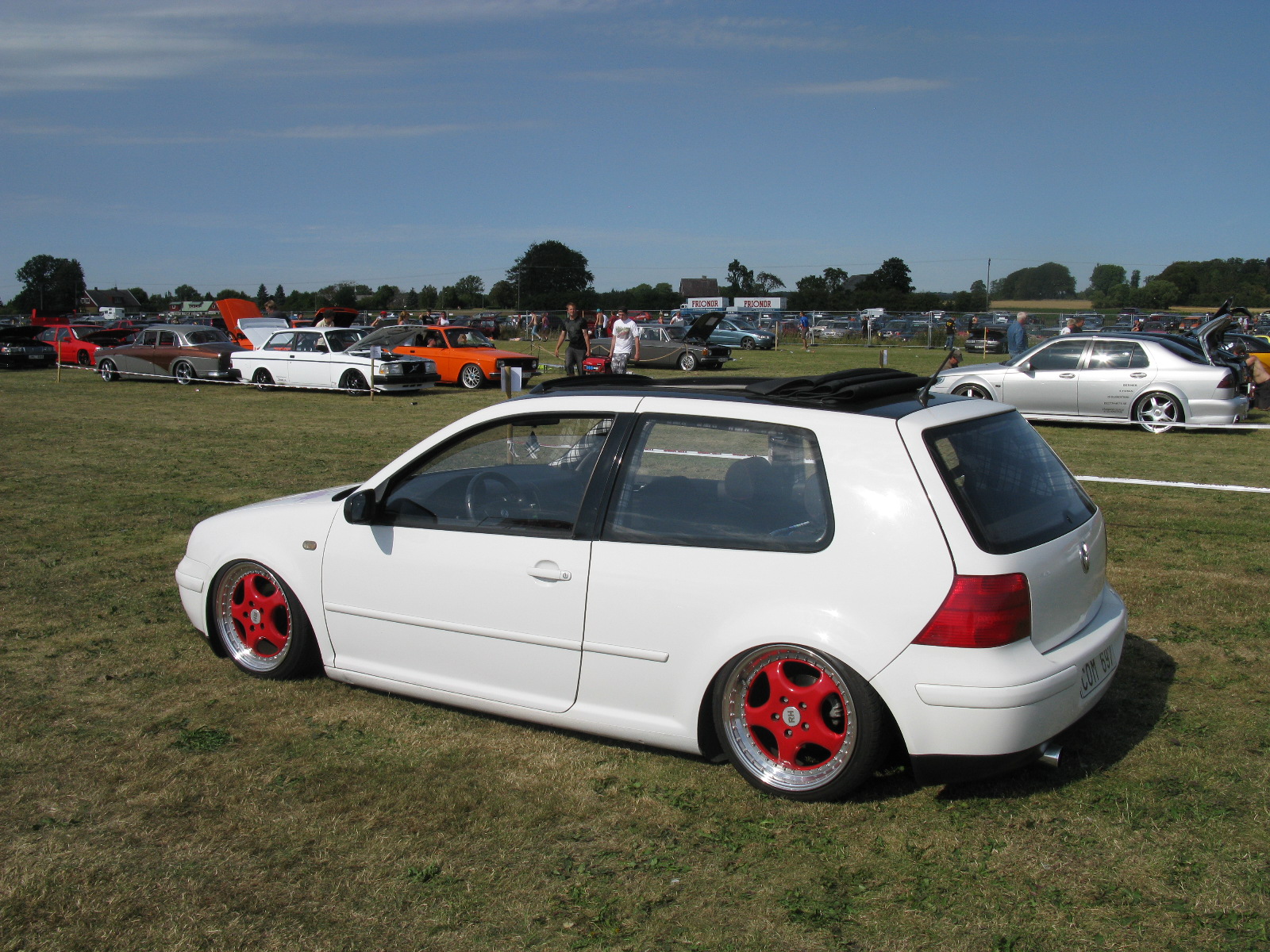 the car is parked in the grass at an event