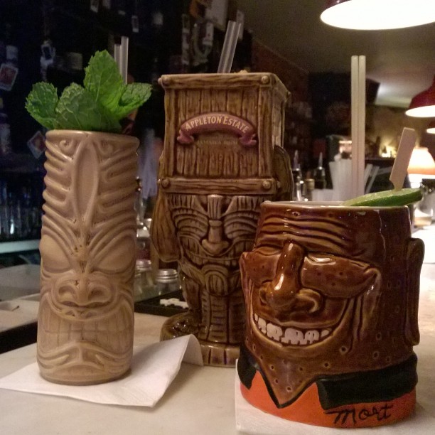 a set of three tiki style coffee mugs