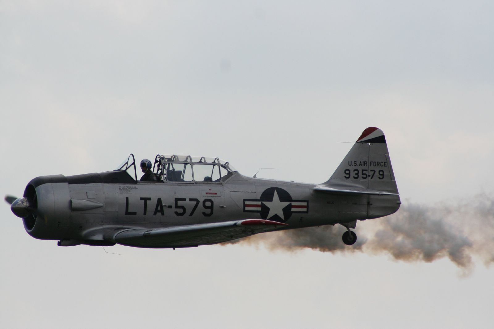 an air plane with smoke coming out of it and in the sky