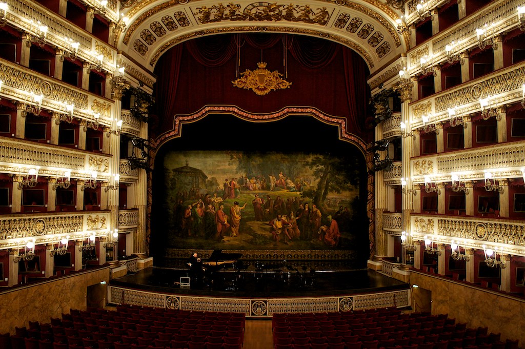 an empty auditorium with a stage and painting