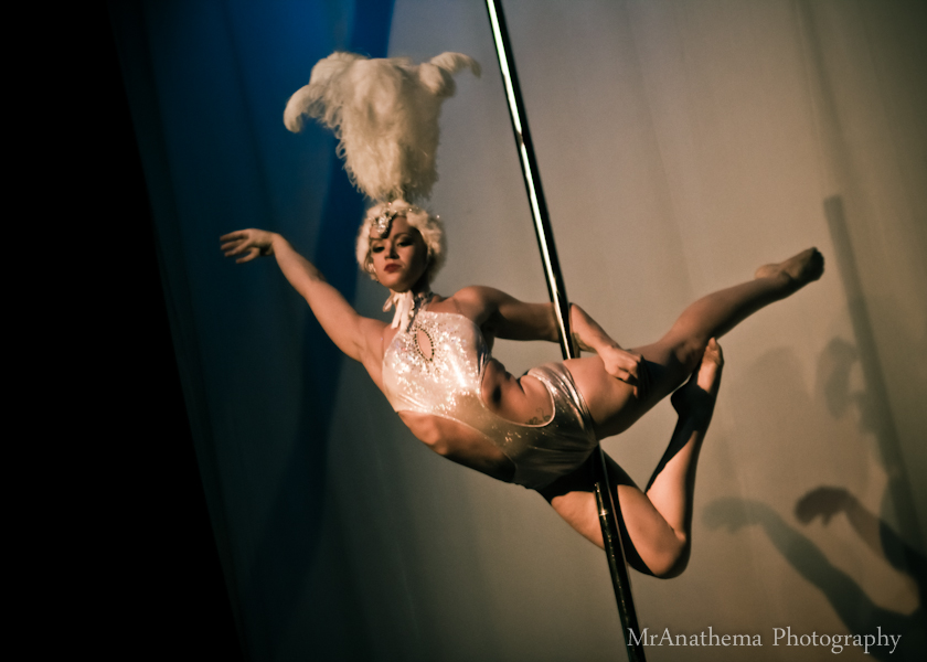 a young woman dancing and holding onto a pole