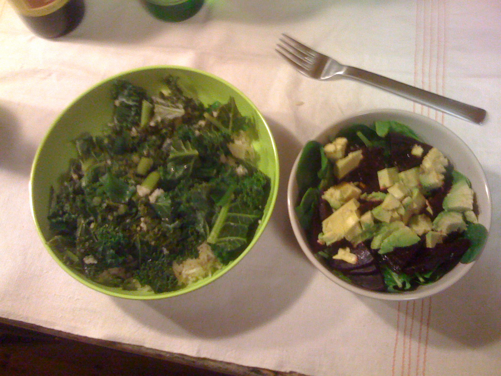 two bowls containing salad, sitting on a table