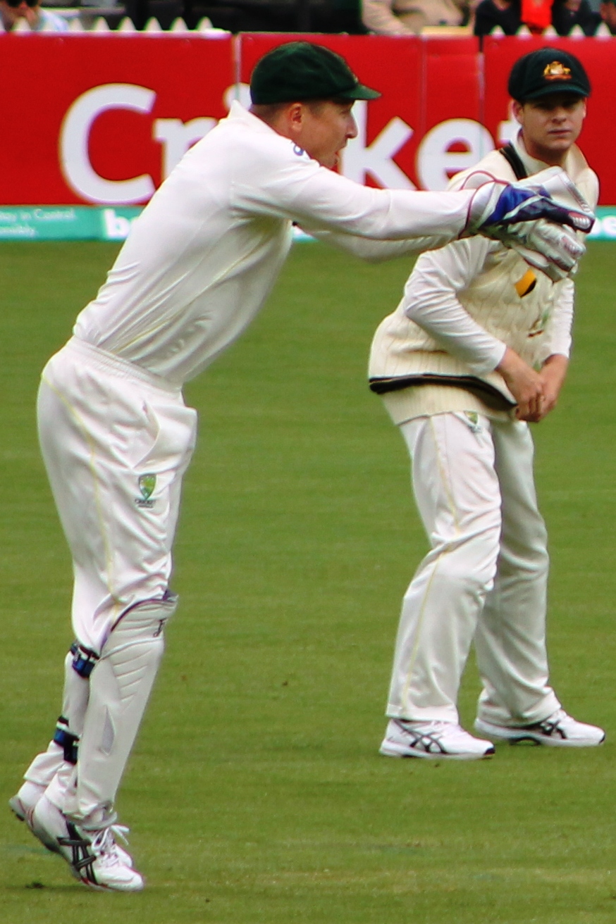 two male players in white playing a game of cricket