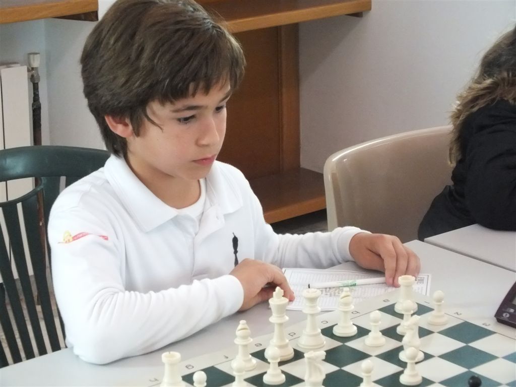 a young child at a table playing chess