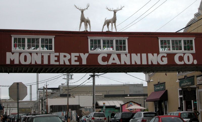 two people on a sign that reads monterey canning co