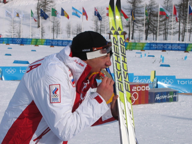 skier in white jacket with green and yellow skis