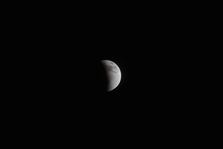 a partially eclipse in the dark sky in the moon