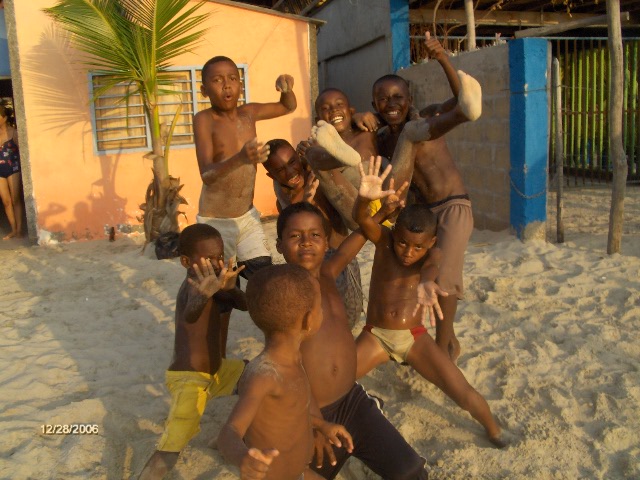 the group of boys on the beach has their arms raised