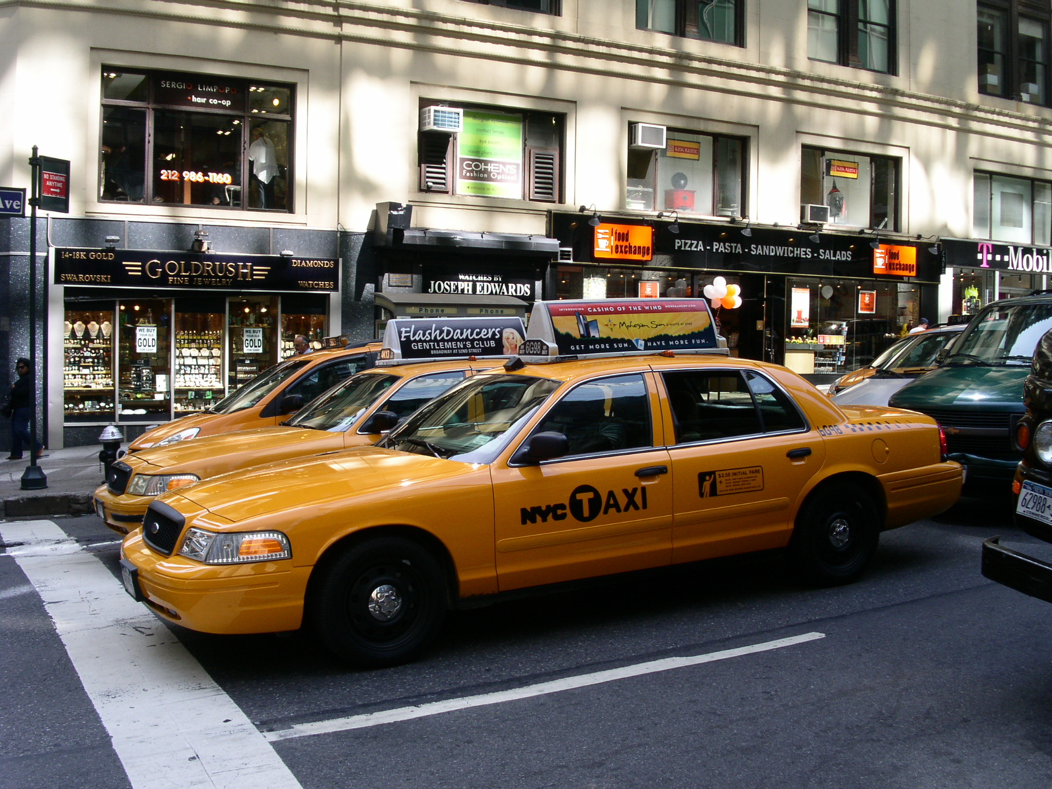 many cars parked in front of stores on a city street