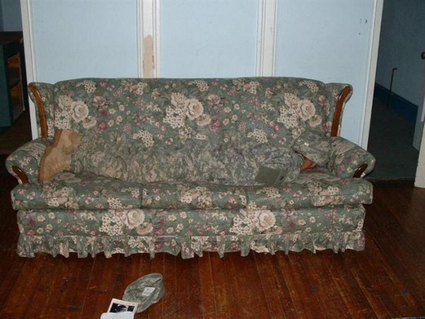 a couch in the living room with a remote control on the floor