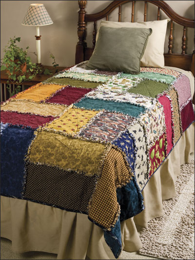 a made bed with multi - colored quilts and pillows