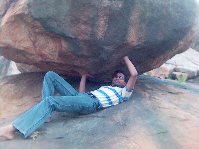 a man is laying on top of a boulder