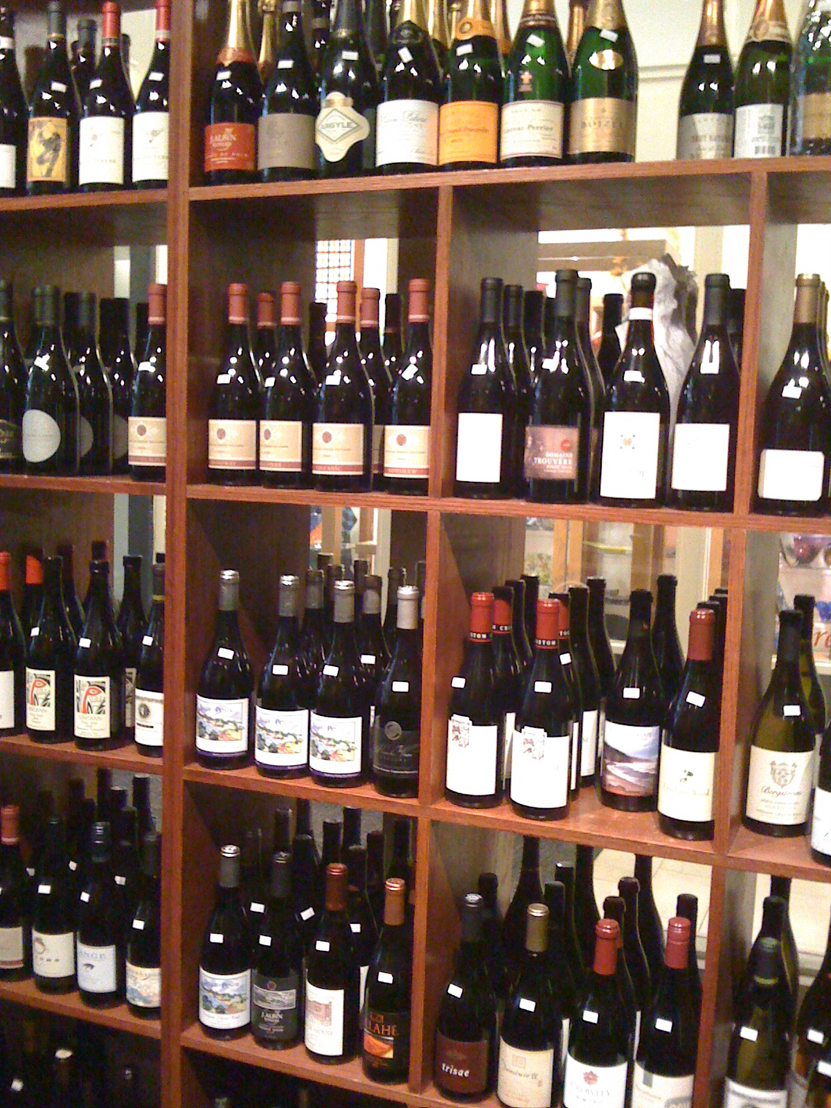 many bottles of alcohol on a wood shelf