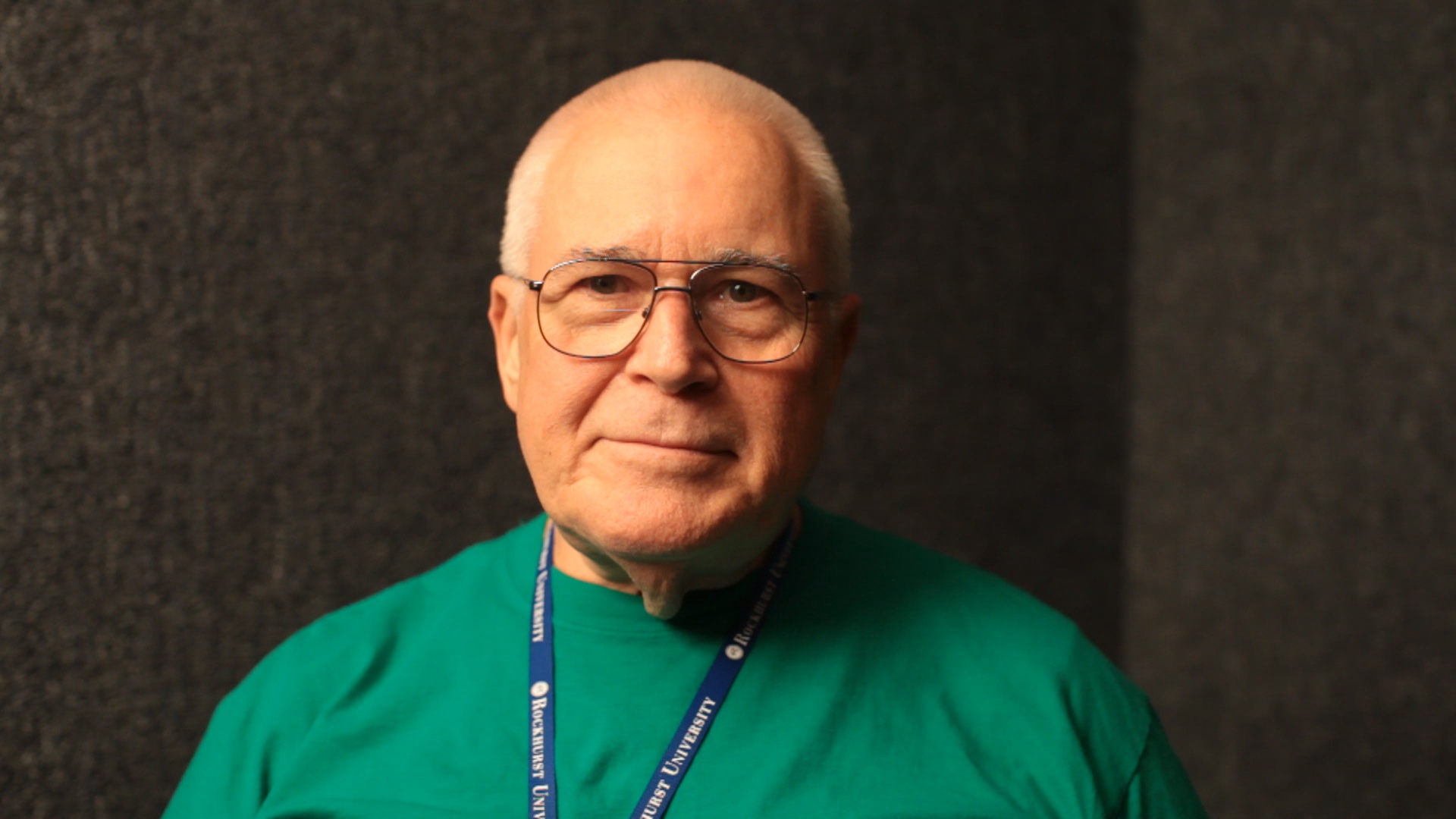 an older man wearing glasses and a green shirt