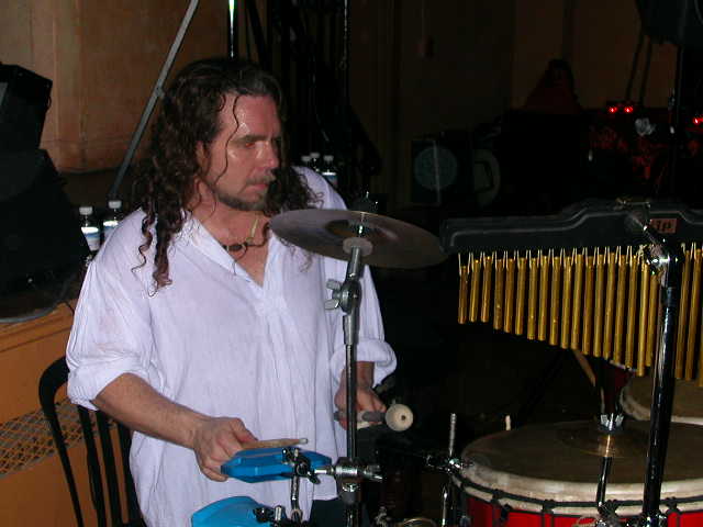 a man with long hair playing the drums