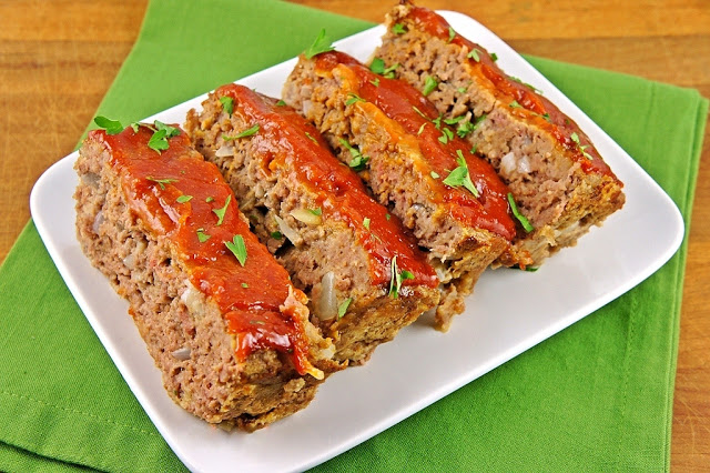 a plate topped with meatloaf covered in ketchup