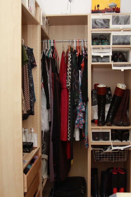 a wardrobe with a suitcase and clothes rack