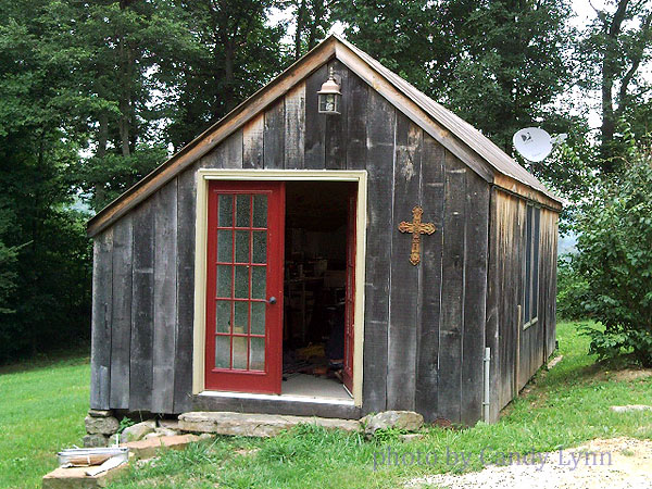 an old outhouse with a red door