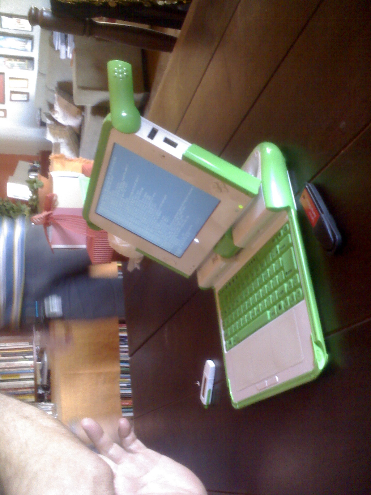 a green laptop is on a wooden desk