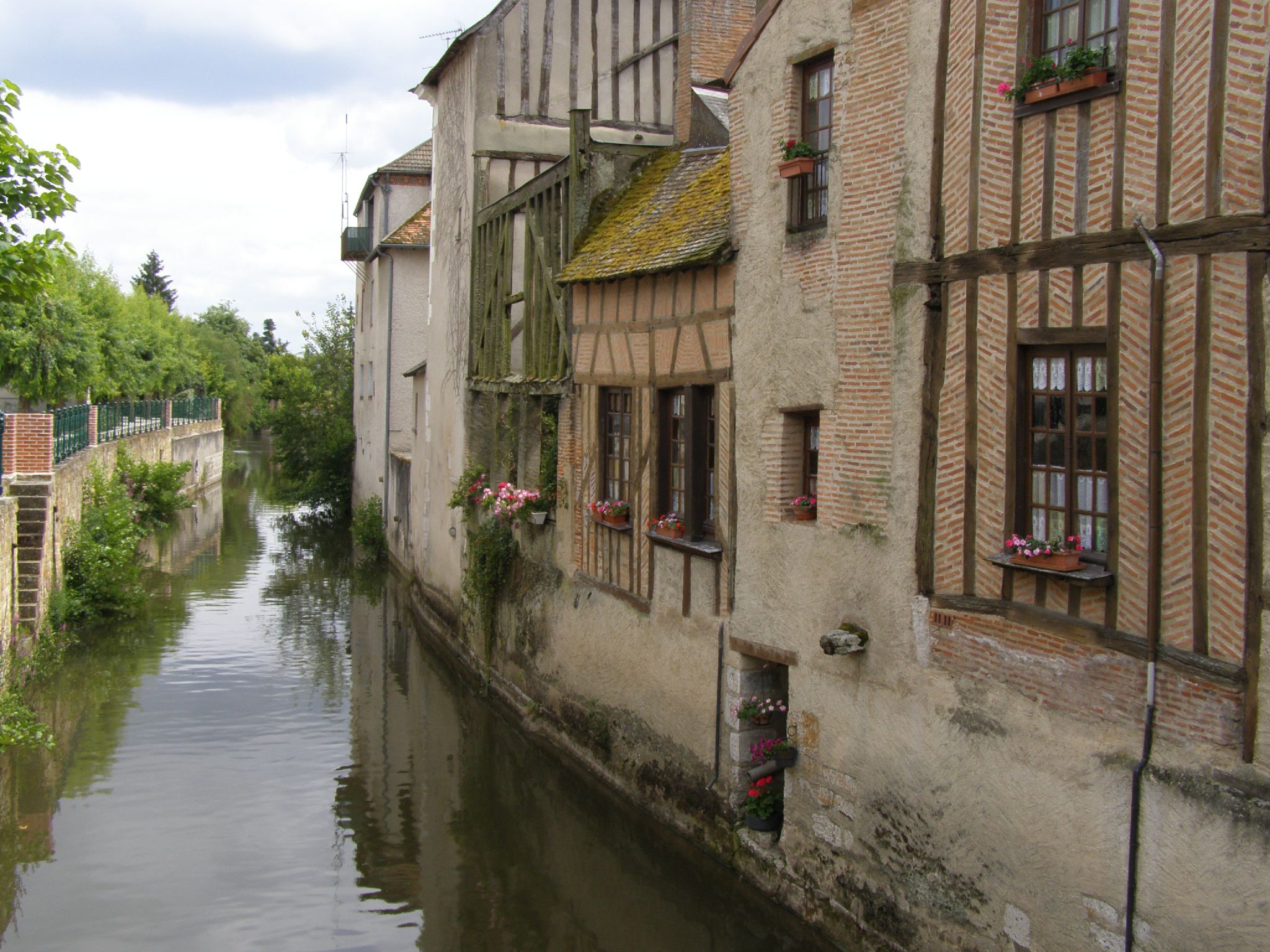 a narrow, river runs between several buildings