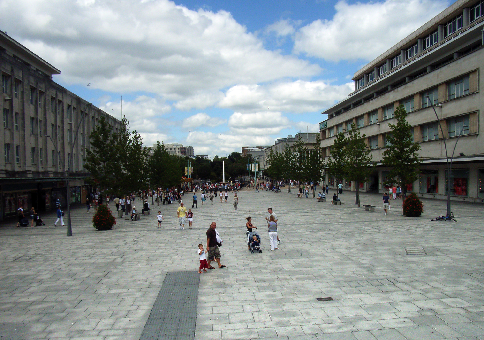 many people walk through a public square in the city