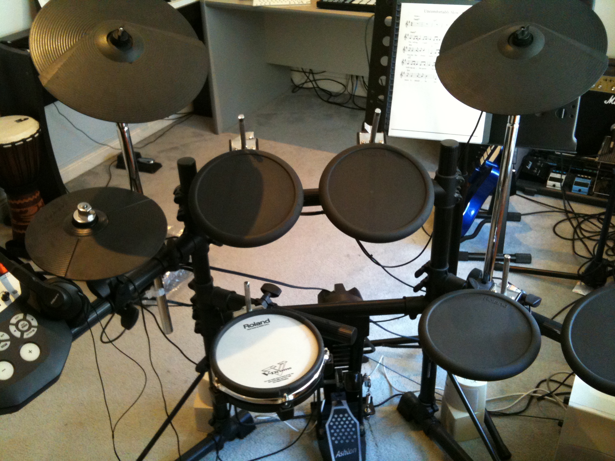 a large group of musical drums next to microphones and music equipment