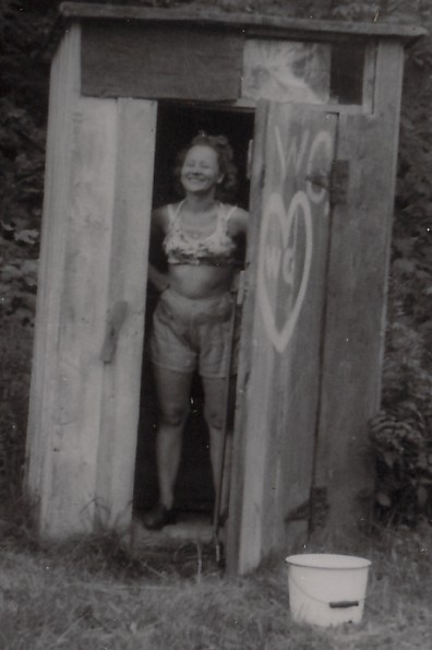 a girl posing in the entrance of a small shed
