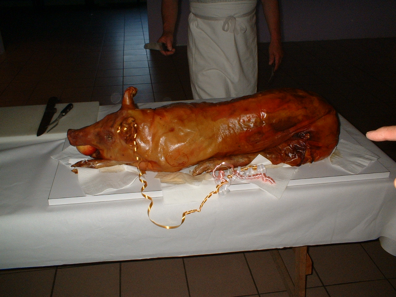 a partially cooked roast pig with orange and yellow paint