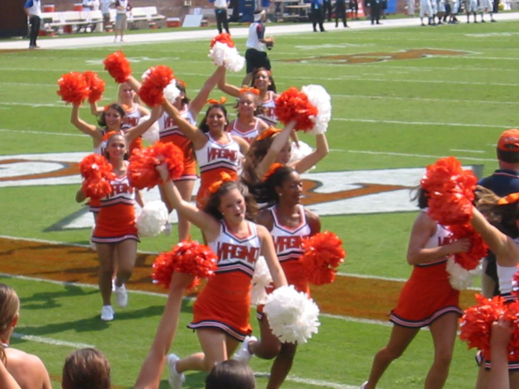several cheerleaders are dancing in unison on the field