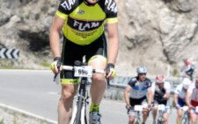 a man in black and yellow jersey riding a bicycle