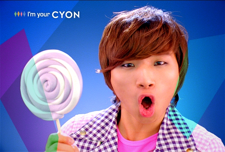 a boy making a silly face holding a giant lollipop