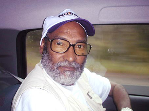 a man driving down the street wearing glasses