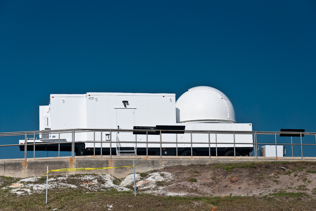 a white building sits on top of a hill