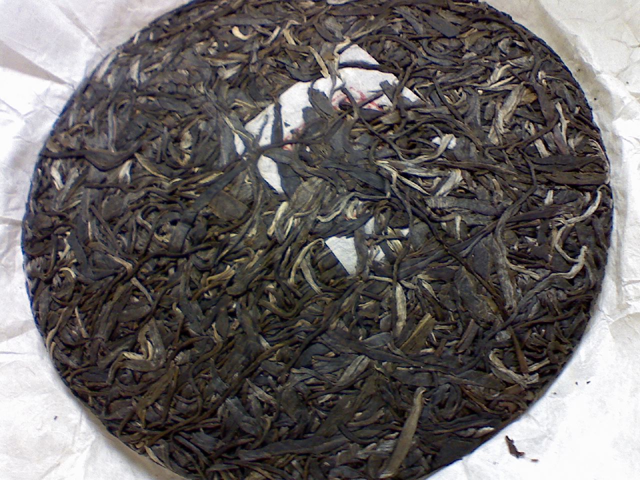 a plate of dried black tea on a white surface