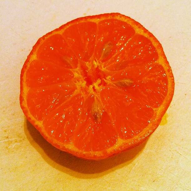 an orange cut in half on a  board