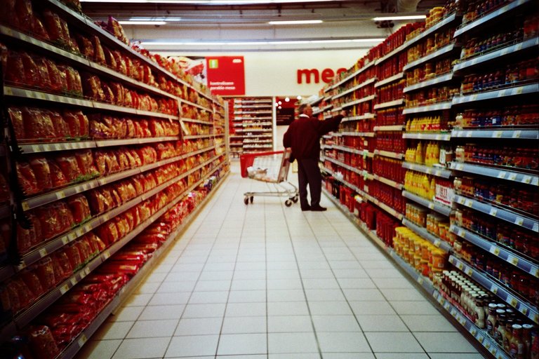 a person walking through a large supermarket aisle