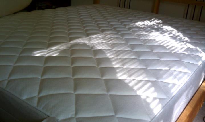the underside of an empty mattress on a bed frame