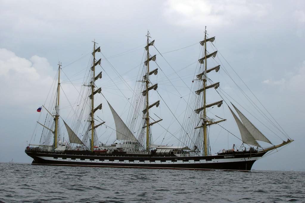 a large sail boat in open water on cloudy day