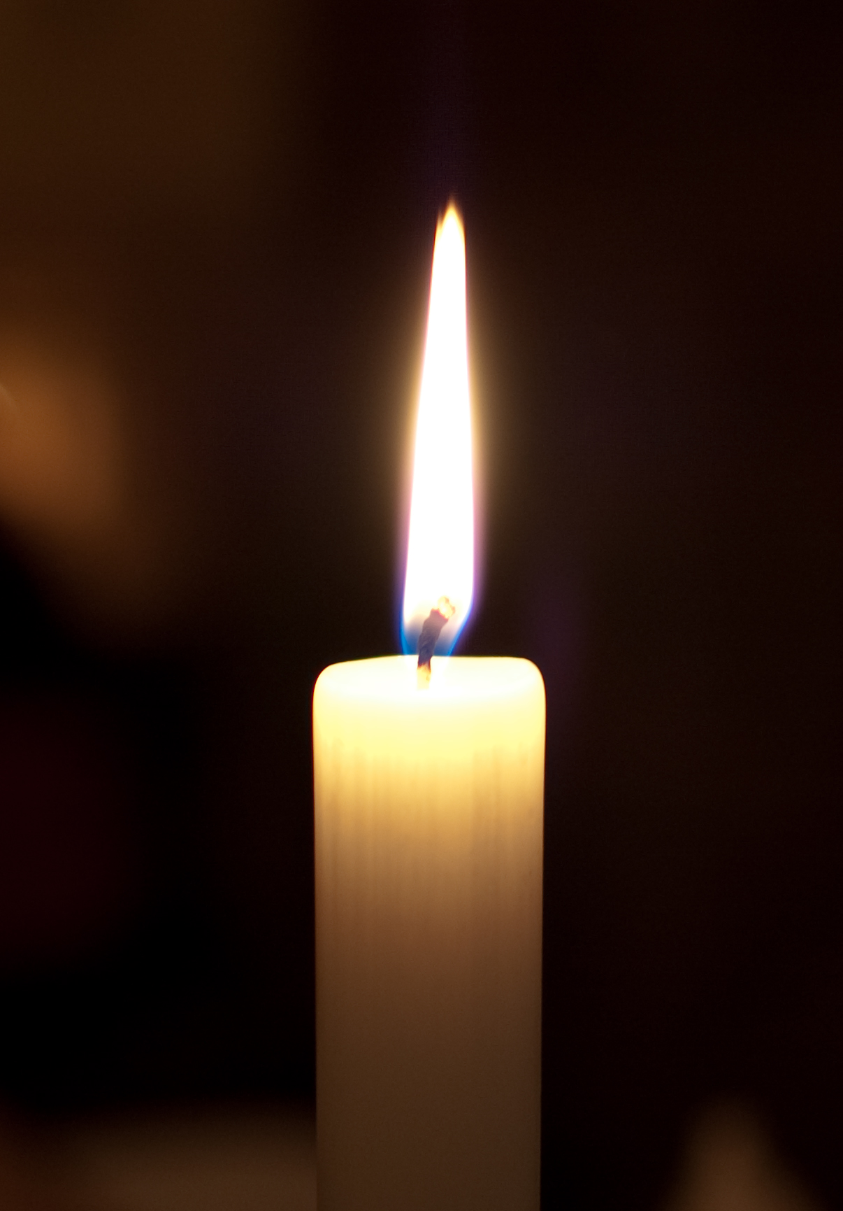 a close up view of a candle with a lit flame