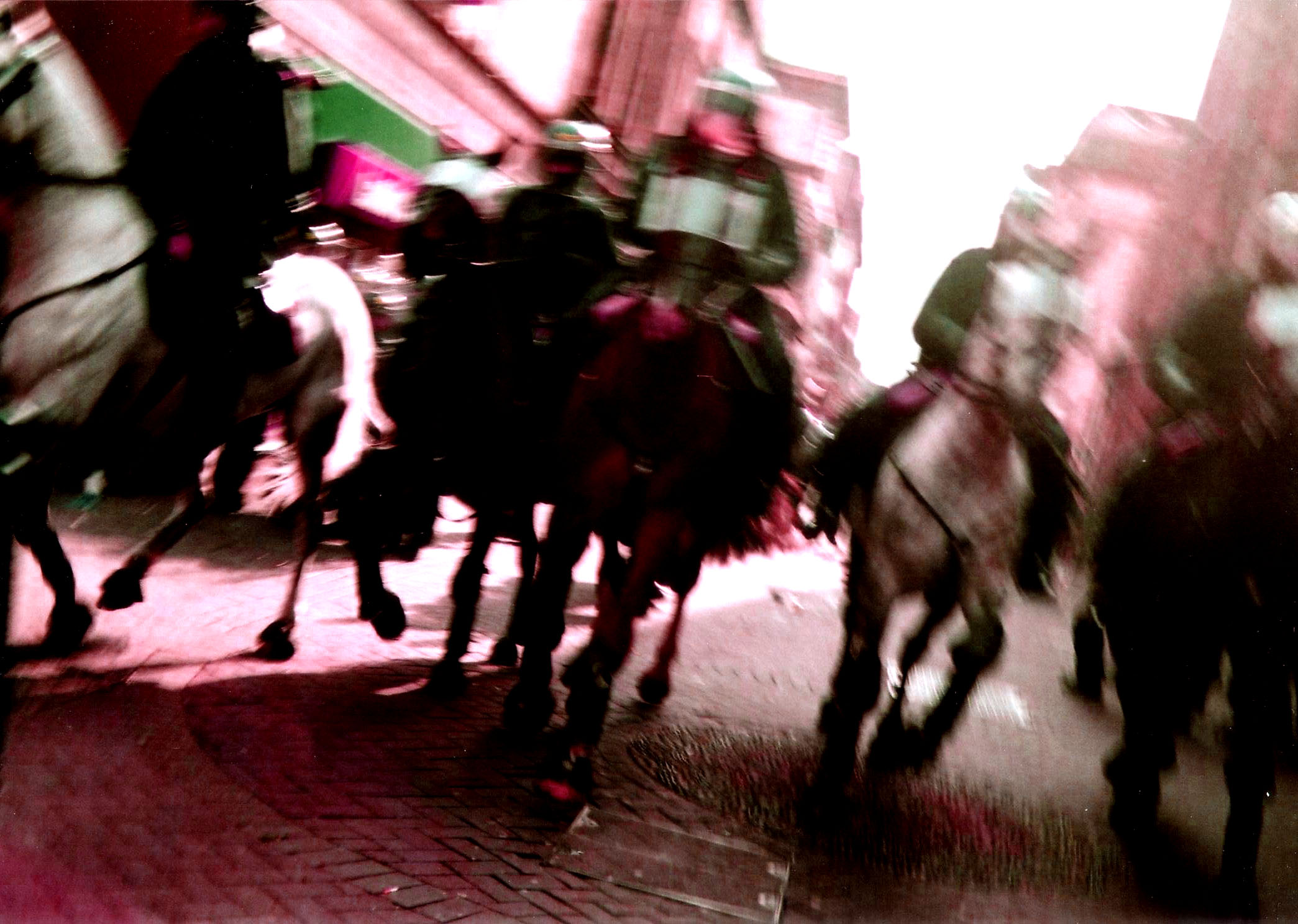 a blurry image shows people in uniforms on horses