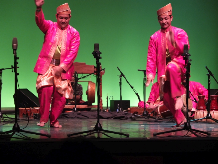 two indian people wearing bright colored clothing on stage