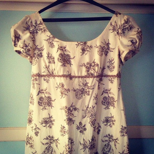 an old shirt with a flower pattern on it hanging on a hanger