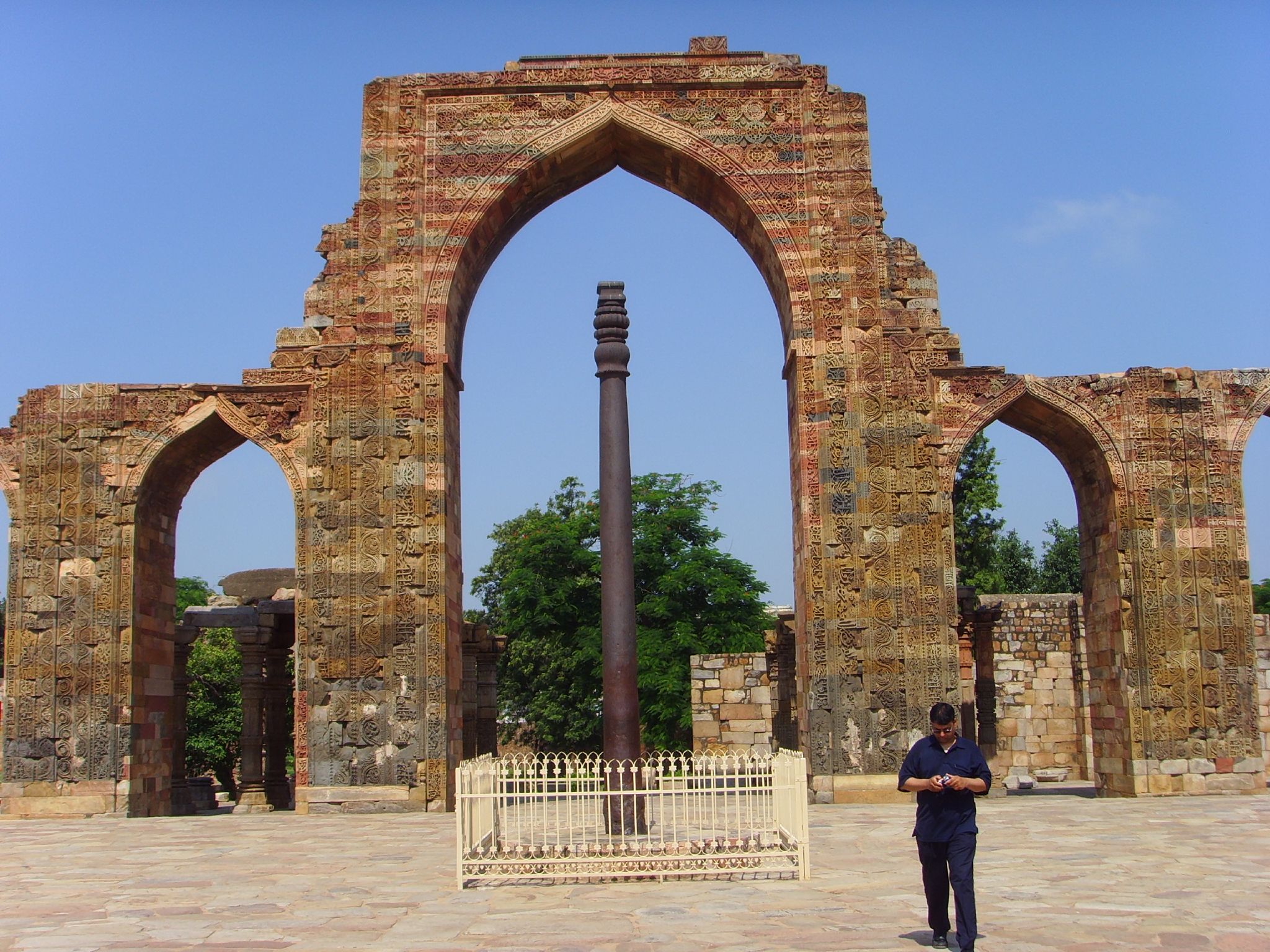 a man standing next to a very tall arch