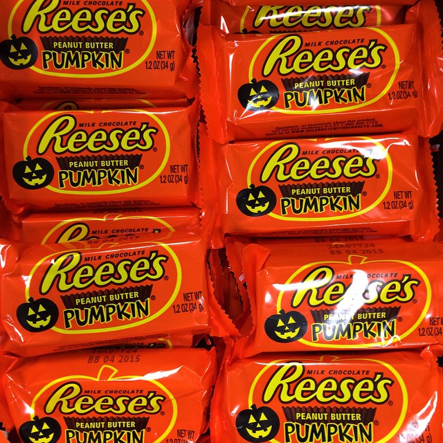 some bags of reese's pumpkin candy are stacked up