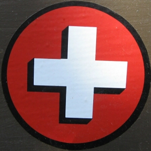 a close up view of the white and black cross on a red circle