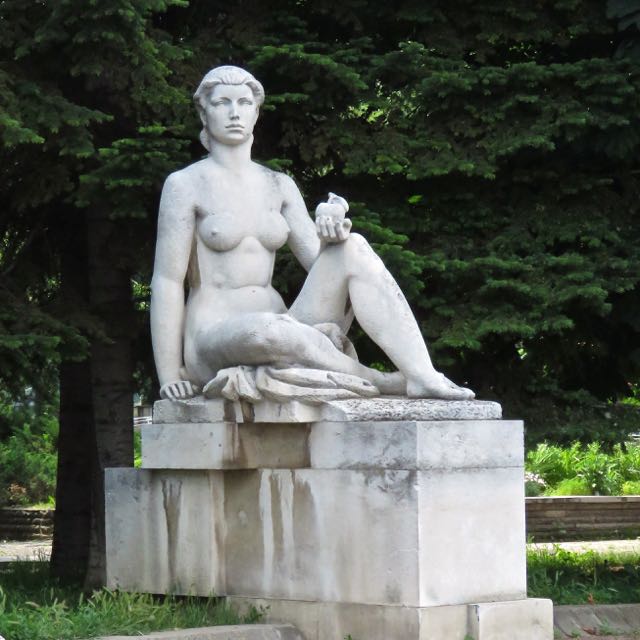 a stone sculpture of a woman resting