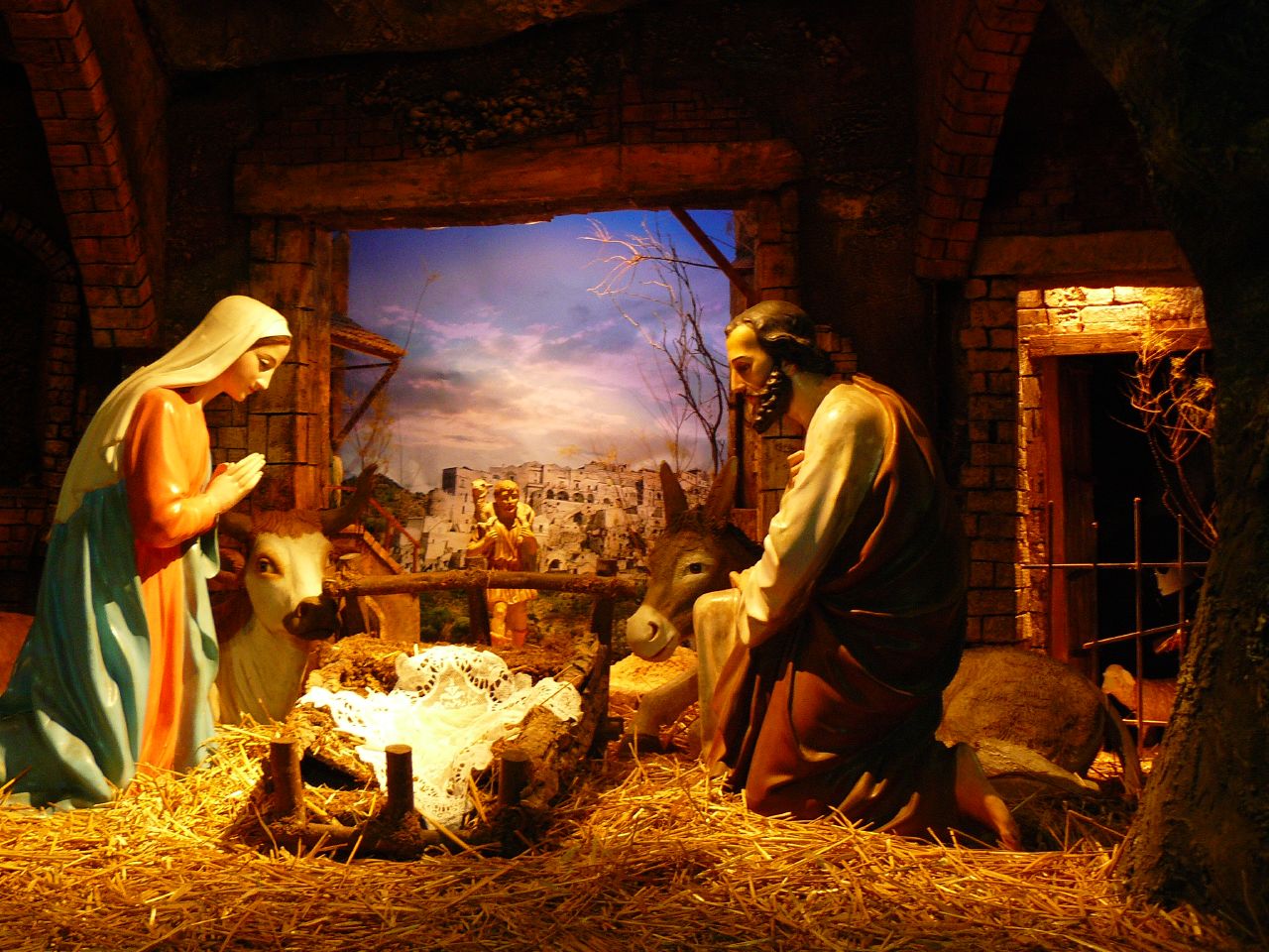 a nativity scene of two people sitting in the mangerms