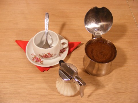 small coffee cup and saucer sitting on a wooden table